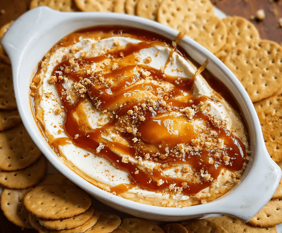 Creamy apple cheesecake dip topped with caramel drizzle, served with sliced apples for a delicious fall-inspired snack.