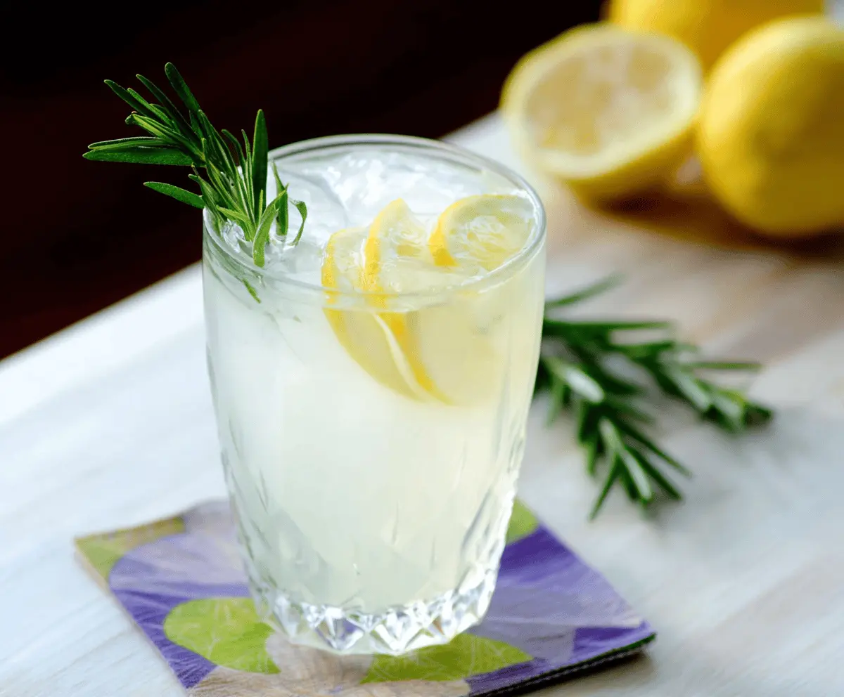 Refreshing Rosemary Gin Fizz cocktail with fresh rosemary garnish in a clear glass