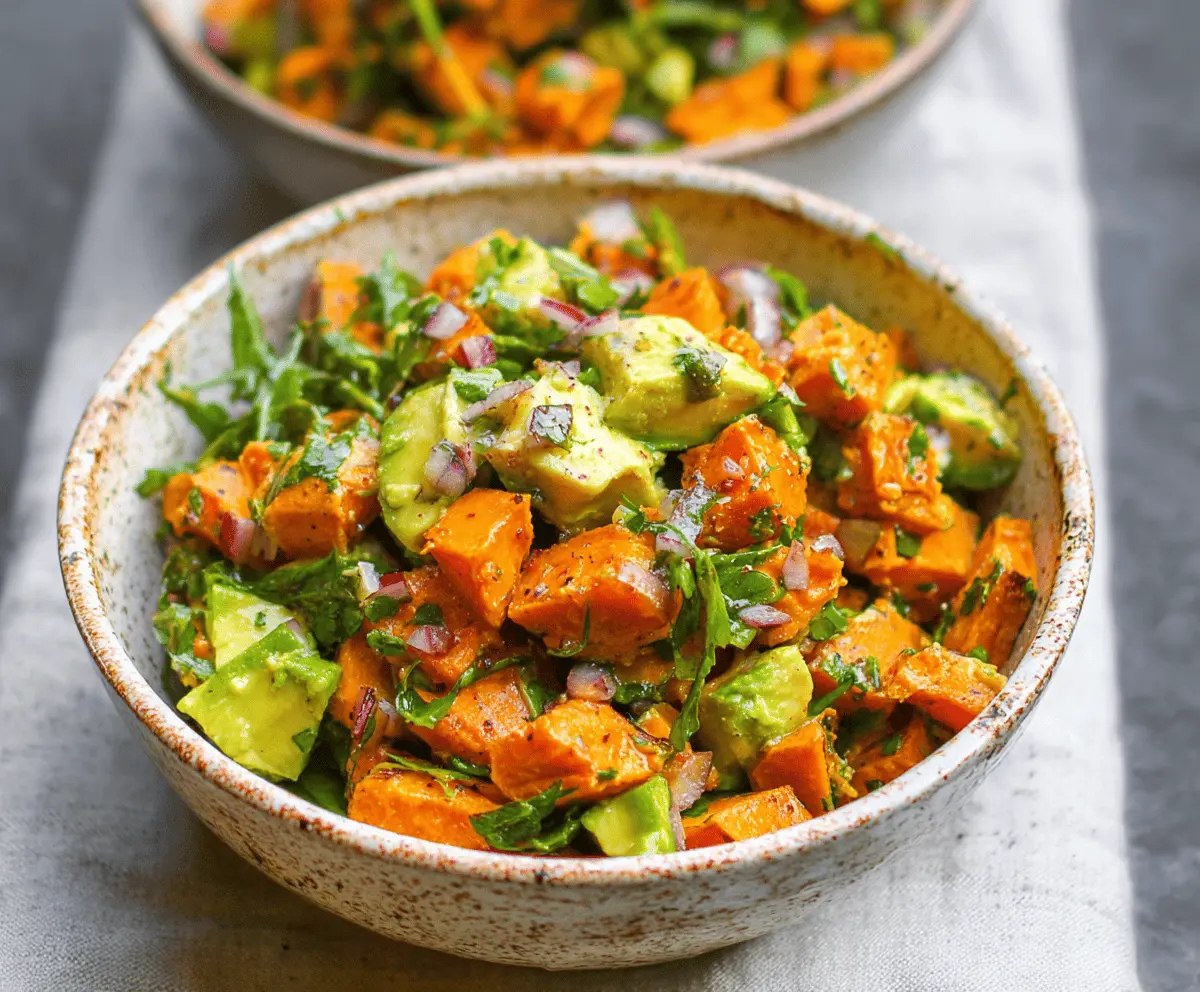 Colorful sweet potato and avocado salad in a bowl, highlighting healthy ingredients and vibrant freshness.