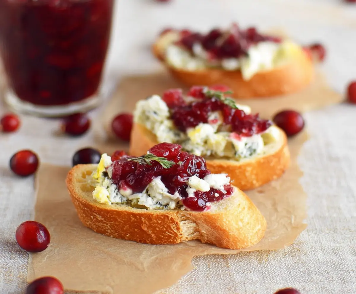 Delicious Blue Cheese Cranberry Crostini topped with fresh cranberries and herbs, perfect for appetizers.