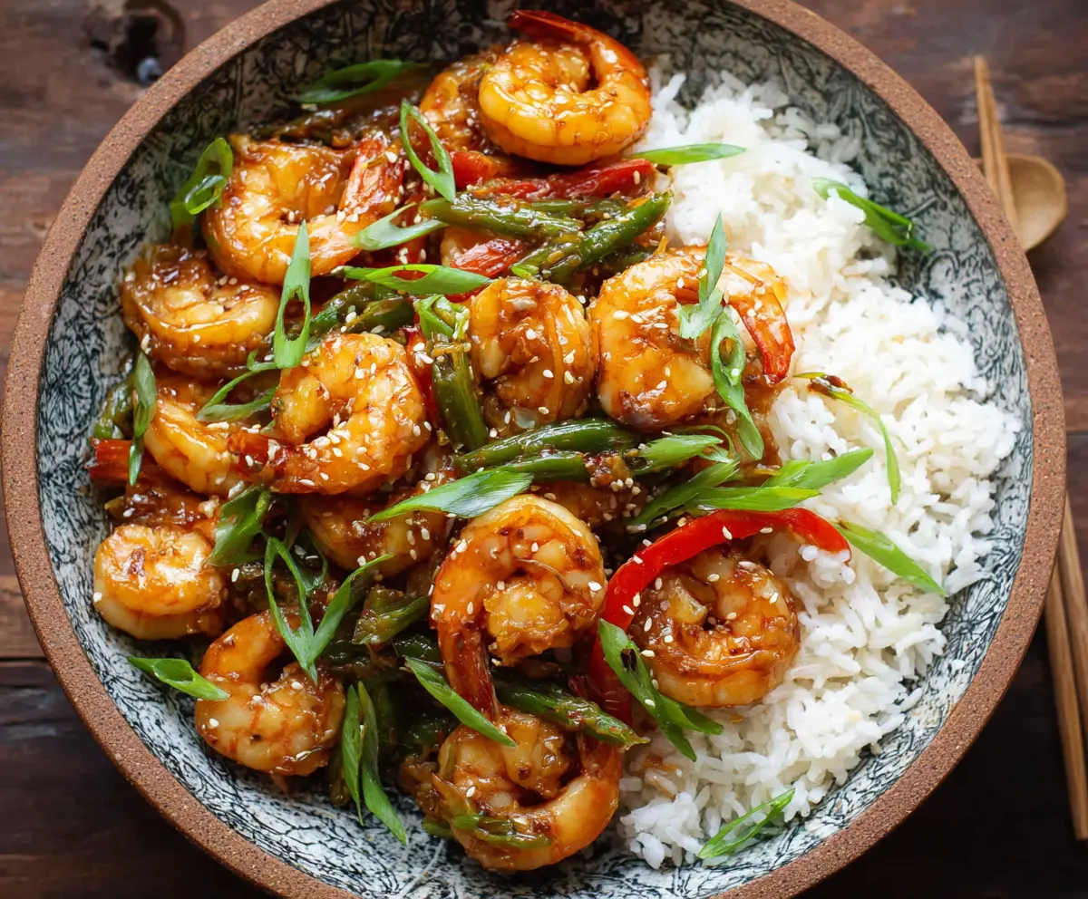 Delicious Chinese Hunan Shrimp served on a white plate, garnished with fresh vegetables.