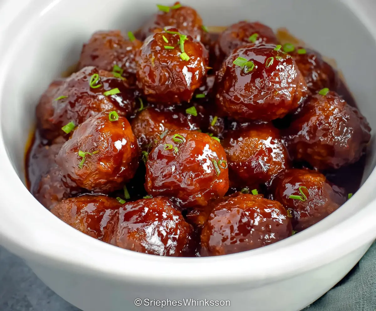 Delicious crockpot grape jelly meatballs served in a savory sauce with fresh herbs