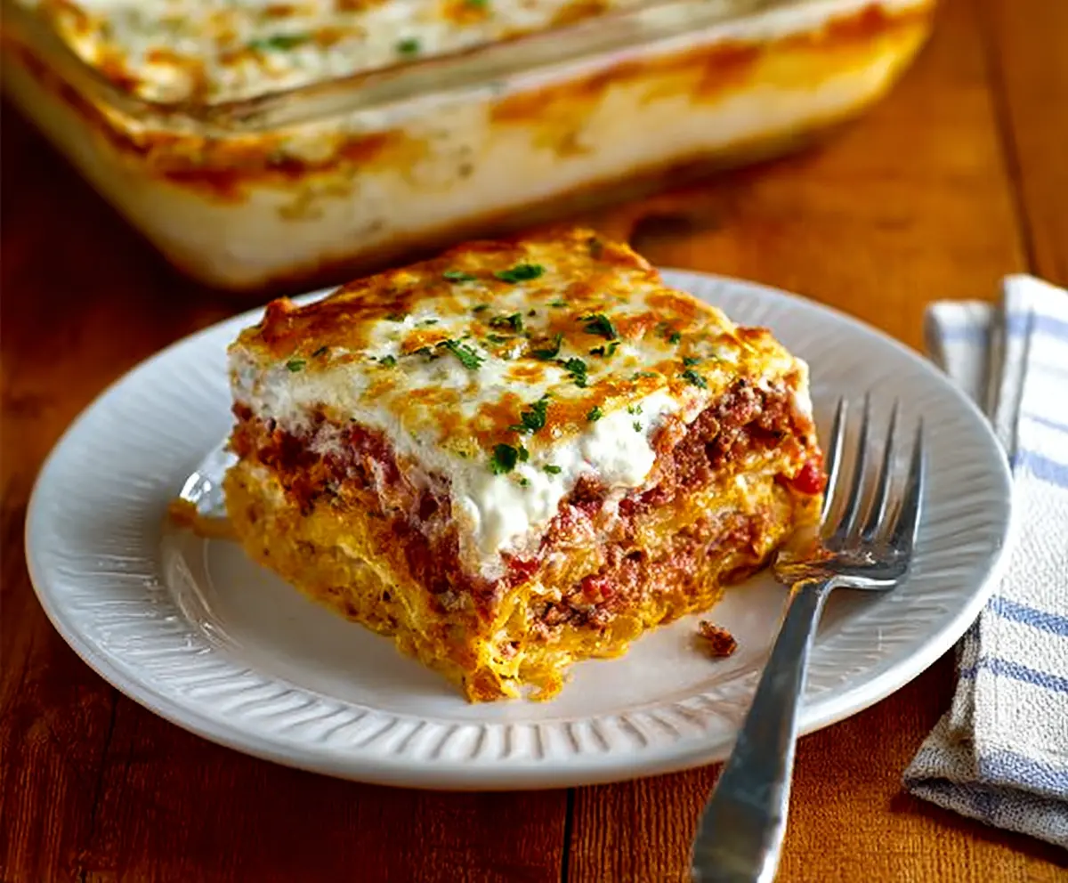 Delicious Spaghetti Squash Lasagna served on a plate with melted cheese and fresh herbs.