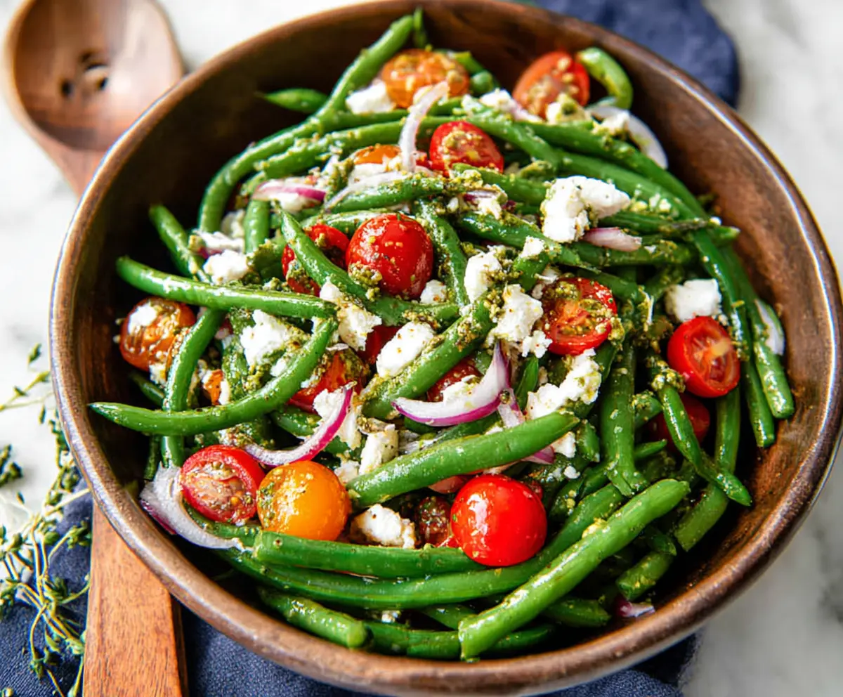 Fresh green bean salad with cherry tomatoes and feta cheese, perfect for a healthy summer dish.